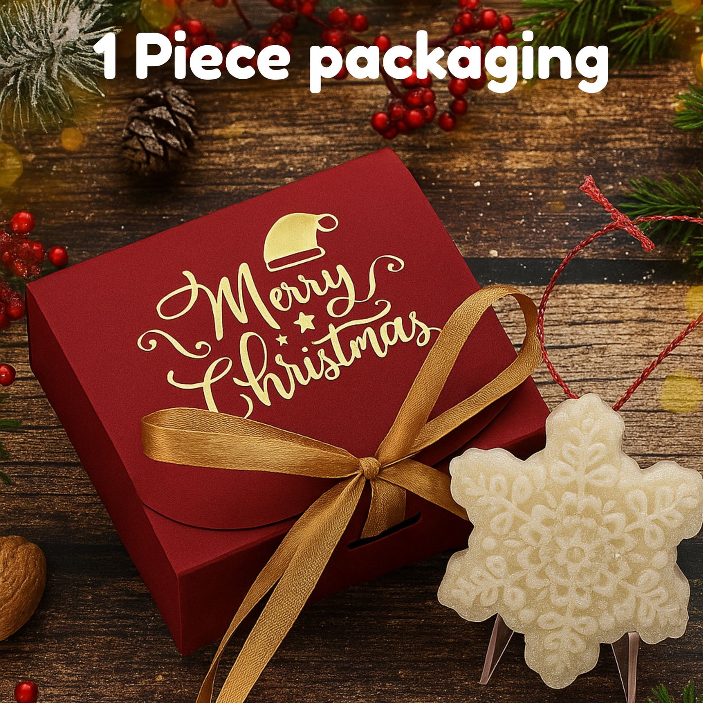 Red Christmas packaging box with gold ribbon and 'Merry Christmas' text on a wooden surface with festive decorations.