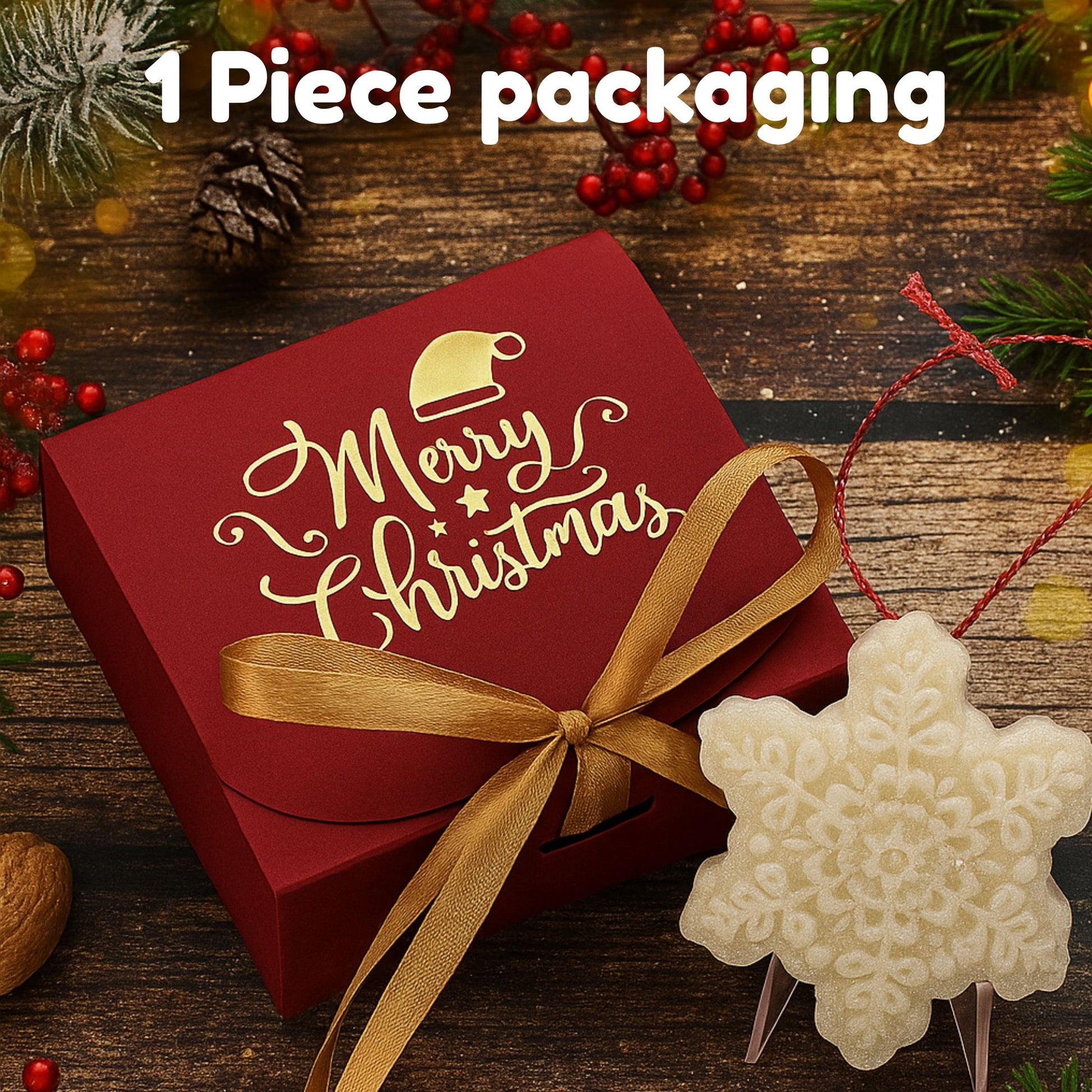 Red Christmas packaging box with gold ribbon and 'Merry Christmas' text on a wooden surface with festive decorations.