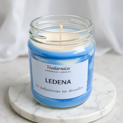 Candle in a glass jar with a label on a marble surface